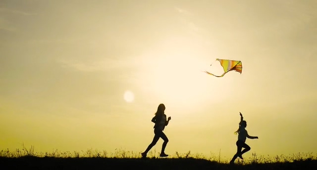 剪影放风筝的两个小孩追逐视频