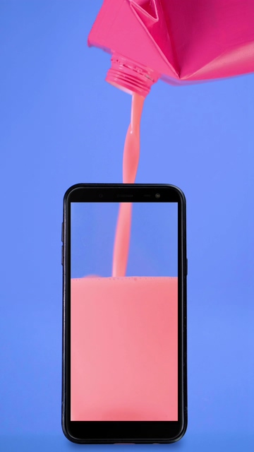 往手机里倒入粉色的果汁液体视频