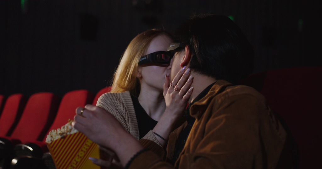在电影院里看电影亲吻的情侣