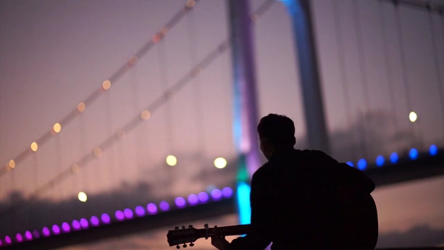 在桥边弹吉他的男人背影视频素材