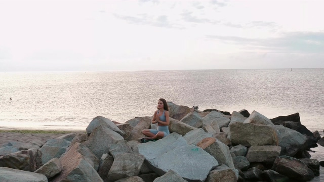 航拍在海边做瑜伽冥想的女人