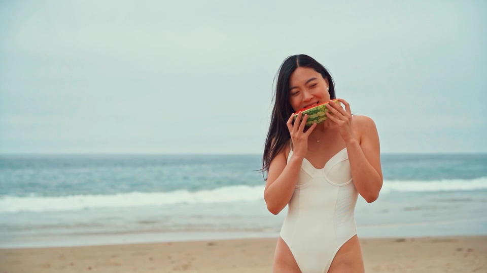 在沙滩海边吃西瓜穿比基尼的美女视频素材